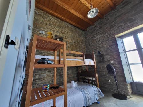 a bedroom with two bunk beds in a brick wall at The Stone Lookout Villa in Apróvaton