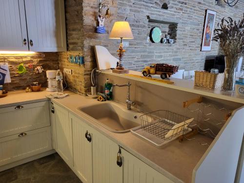 a kitchen with a sink and a brick wall at The Stone Lookout Villa in Apróvaton