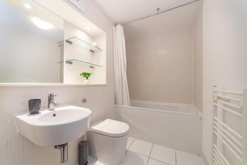 倫敦的住宿－The London Bridge Collection，白色的浴室设有水槽和卫生间。