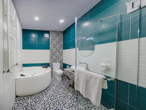 La salle de bains bleue et blanche est pourvue d'une baignoire et de toilettes. dans l'établissement Rivendell Boutique By Umbrella, à Tbilissi