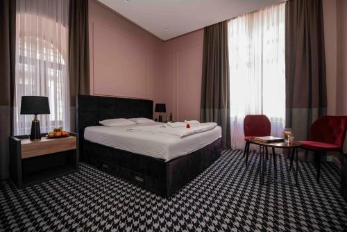 um quarto de hotel com uma cama, uma mesa e cadeiras em Hotel Platani em Trebinje