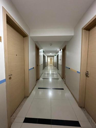 an empty corridor of an office building with doors and mats at D'University in Manila