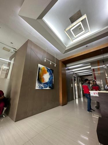 a lobby of a building with a painting on the wall at D'University in Manila