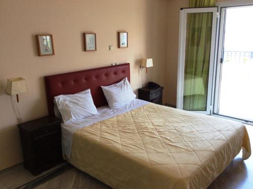 a bedroom with a large bed with white pillows at Angelica Villas Hotel Apartments in Ancient Epidauros