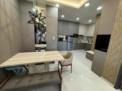 Dangabay 2bedroom Seaview Luxury Design Unit في جوهور باهرو: مطبخ مع طاولة وكراسي خشبية وغرفة طعام
