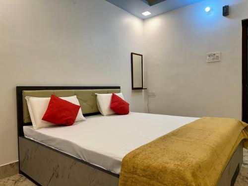 a bedroom with a bed with red and white pillows at Hotel Nalanda City in Nalanda