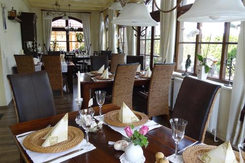 - une salle à manger avec une table, des chaises, des tables et des chaises dans l'établissement Weißer Stein Jonsdorf, à Jonsdorf