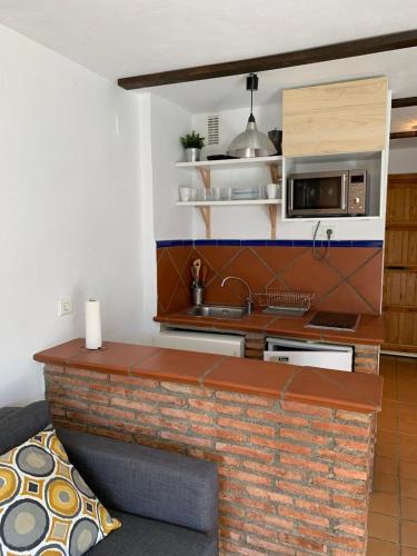 uma cozinha com um balcão de tijolos e um lavatório em Estudio con vistas y garaje gratuito em Sierra Nevada
