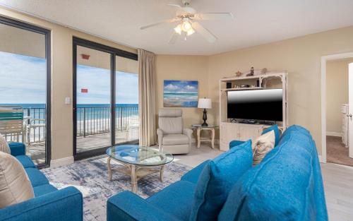 a living room with a blue couch and a television at Phoenix X 317 in Orange Beach