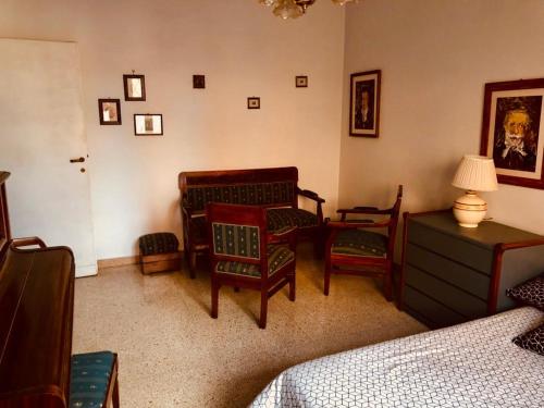 ein Schlafzimmer mit einem Bett, einem Stuhl und einer Kommode in der Unterkunft SAN PIETRO in Rom