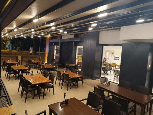 un ristorante vuoto con tavoli e sedie in legno di Comfy Otel Antalya Lara a Antalya (Adalia)