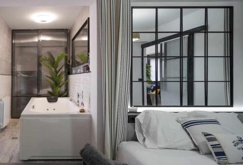a bedroom with a bed and a sink and a mirror at Atico Lujo Costa Vasca Bilbaoterraza mar jacuzi in Santurce