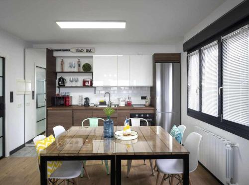 a dining room with a table and chairs in a kitchen at Atico Lujo Costa Vasca Bilbaoterraza mar jacuzi in Santurce