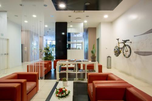 a lobby with red chairs and a table and a bike on the wall at Euro Hotel Residence in Concorezzo