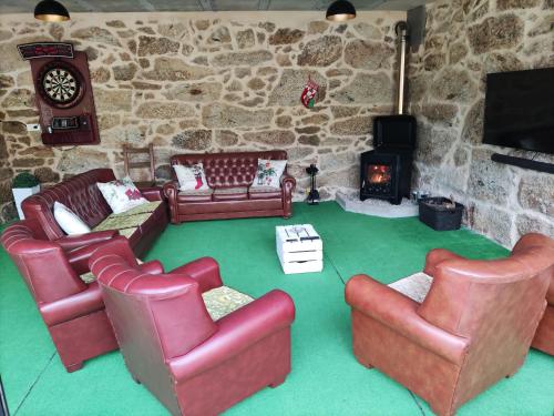 a living room with leather furniture and a fireplace at Casa Antonio Luneda in Parada de Achas