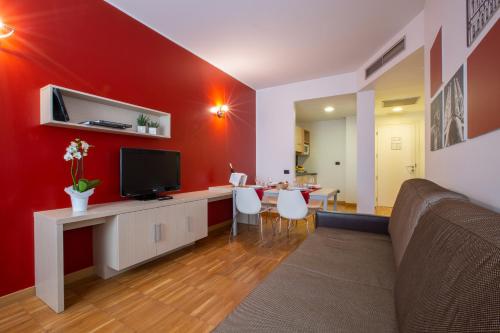 a living room with a red accent wall at Euro Hotel Residence in Concorezzo
