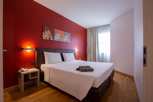 a bedroom with a large bed with a red wall at Euro Hotel Residence in Concorezzo