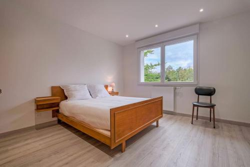 une chambre avec un lit, une fenêtre et une chaise dans l'établissement Maison proche Disney/Parking gratuit, à Mareuil-lès-Meaux