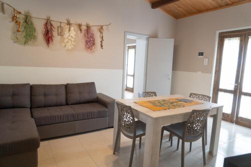 a living room with a table and chairs and a couch at La Corte dell’Isola in Pachino