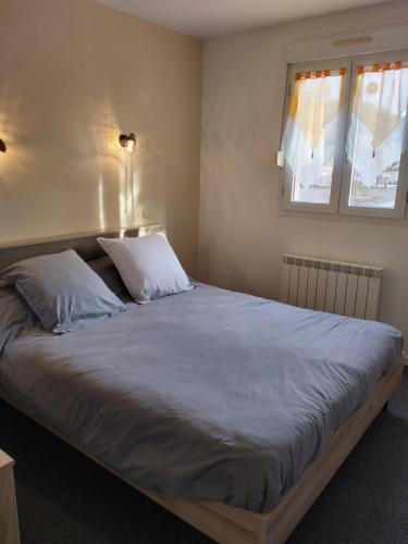 - une chambre avec un grand lit et 2 oreillers dans l'établissement Chez Pomy, à Cransac