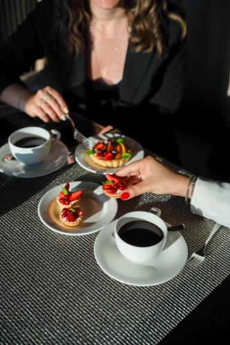 a woman sitting at a table with plates of food and coffee at Key Hotel in Izmir
