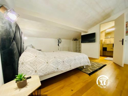 a bedroom with a large white bed in a room at Loft cocon climatisé - Imprenable vue sur le château Comtal in Carcassonne