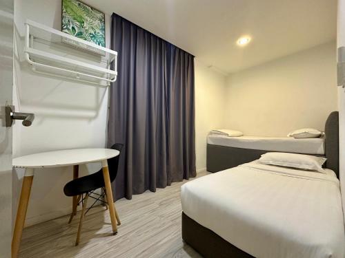 a room with two beds and a table and a window at Utopian Homes at Sutera Avenue in Kota Kinabalu