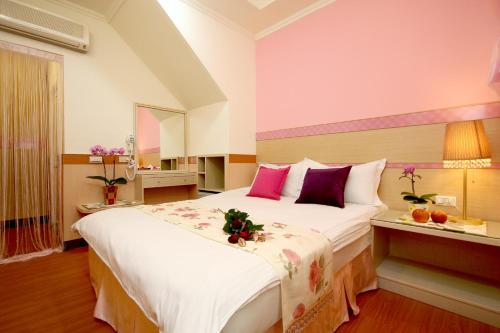 花蓮市的住宿－花蓮海濱民宿，卧室配有一张大白色床,提供粉色和紫色枕头