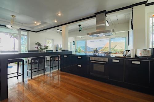 a kitchen with black cabinets and a large window at Patong Blue House Panorama View in Patong Beach