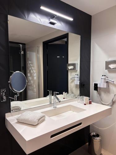 a bathroom with a sink and a large mirror at Le Grand Hôtel Le Touquet-Paris-Plage in Le Touquet-Paris-Plage