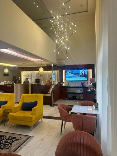 a lobby with a yellow couch and chairs and a table at سكون سويت للشقق الفندقية in Hail