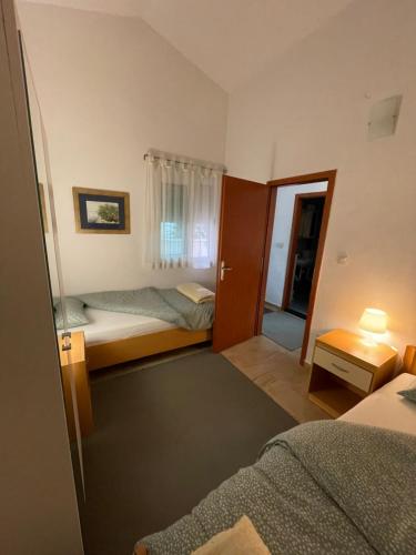 Habitación con 2 camas y puerta a un dormitorio en Apartments Leko, en Žuljana