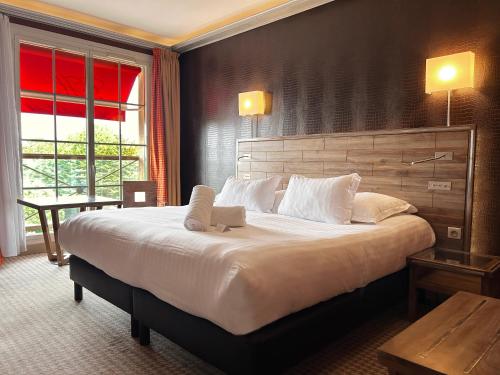a bedroom with a large bed with a laptop on it at Le Grand Hôtel Le Touquet-Paris-Plage in Le Touquet-Paris-Plage