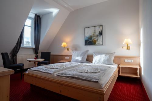 ein Schlafzimmer mit einem großen Bett in einem Zimmer in der Unterkunft Deutenhof Hotel, Restaurant & Veranstaltung in Bad Abbach