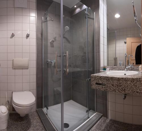 e bagno con doccia, servizi igienici e lavandino. di Deutenhof Hotel, Restaurant & Veranstaltung a Bad Abbach