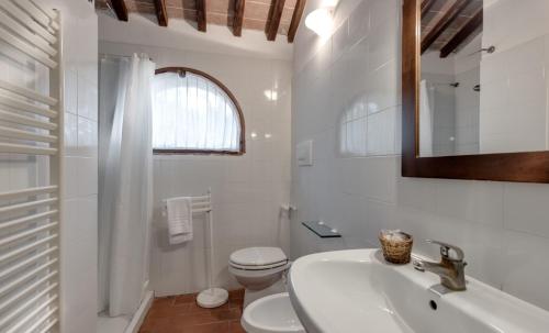 a white bathroom with a sink and a toilet at Fattoria Agriturismo Nerbona in Casole dʼElsa