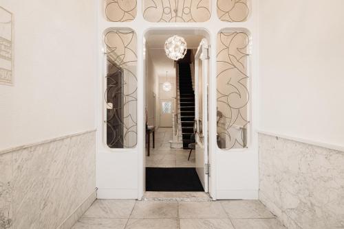 a hallway with white walls and an open door at NEWLY OPENED - Parklane Hotel in Amsterdam