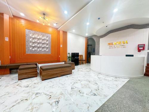 a lobby with a reception desk and a marble floor at Milanesa Hotel and Apartment in Vung Tau