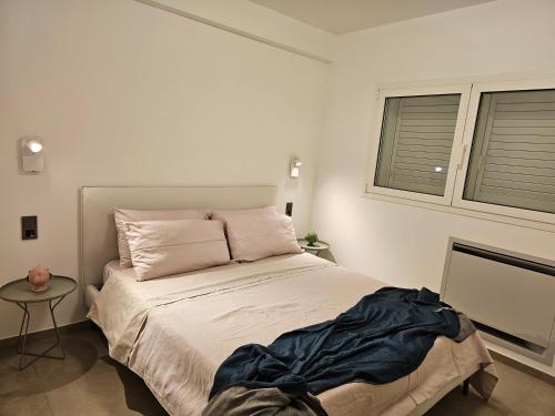 a bedroom with a large bed and two windows at Villa Dune Luxury Roof Top Pool Wellness in Gallipoli