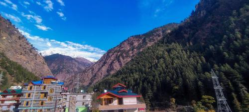 a group of buildings in front of a mountain at Little Hamlet Choj in Kasol