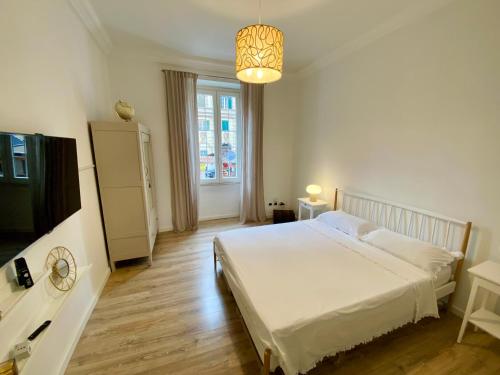 - une chambre avec un lit blanc et une télévision dans l'établissement Giò House - Palazzo Storico, à Rome
