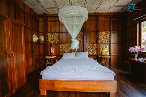 a bedroom with a bed and a chandelier at Muong Dinh Lodge in Ấp Nhơn Bình