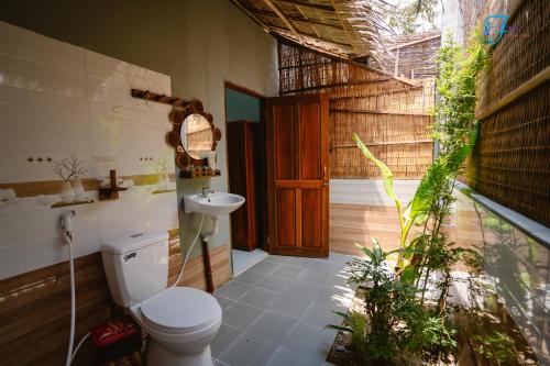y baño con aseo y lavamanos. en Muong Dinh Lodge en Ấp Nhơn Bình