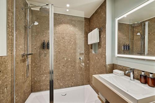 y baño con ducha y lavamanos. en Residence Inn by Marriott Munich Central en Múnich