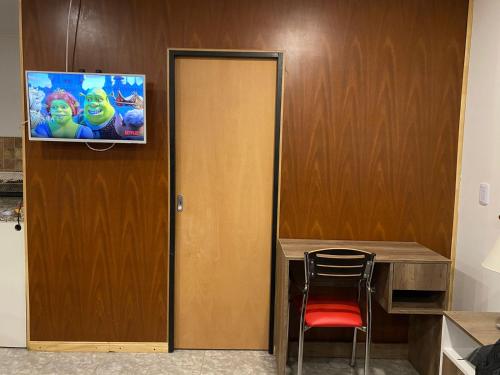 um quarto com uma porta com uma televisão na parede em Descanso Río Grande em Rio Grande