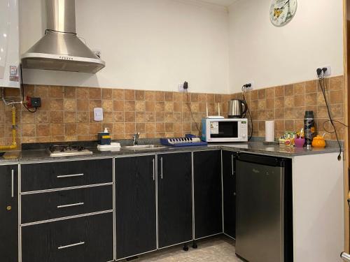 a kitchen with black cabinets and a microwave at Descanso Río Grande in Río Grande