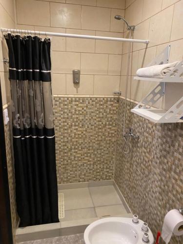 a shower with a black shower curtain next to a sink at Descanso Río Grande in Río Grande