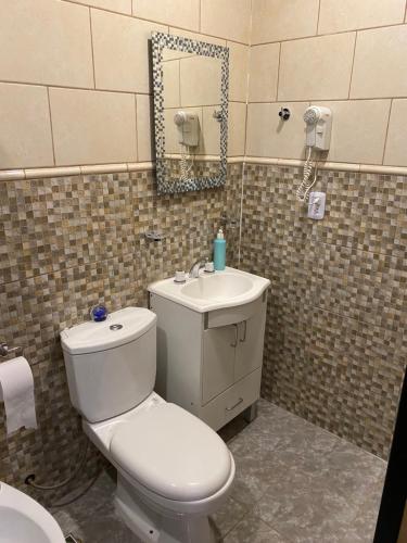 a bathroom with a toilet and a sink and a mirror at Descanso Río Grande in Río Grande