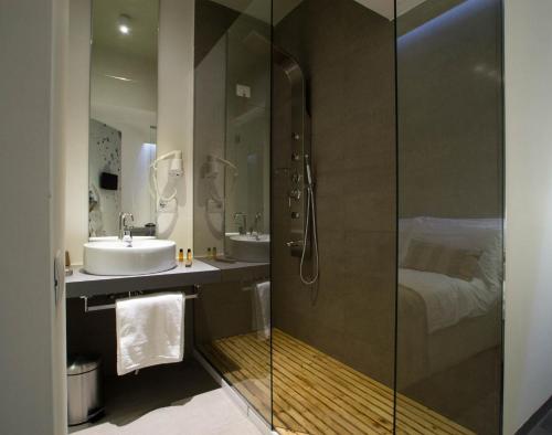 a bathroom with a shower and a sink and a bed at Hotel Santa Brigida in Naples