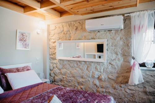 1 dormitorio con 1 cama y pared de piedra en Villa Pialia 